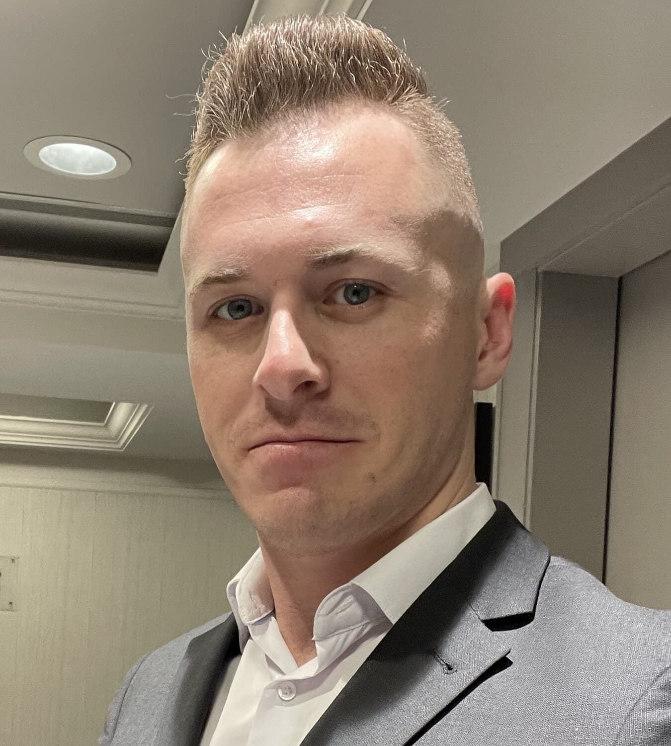Austin wearing a suit jacket with an orange pocket square.