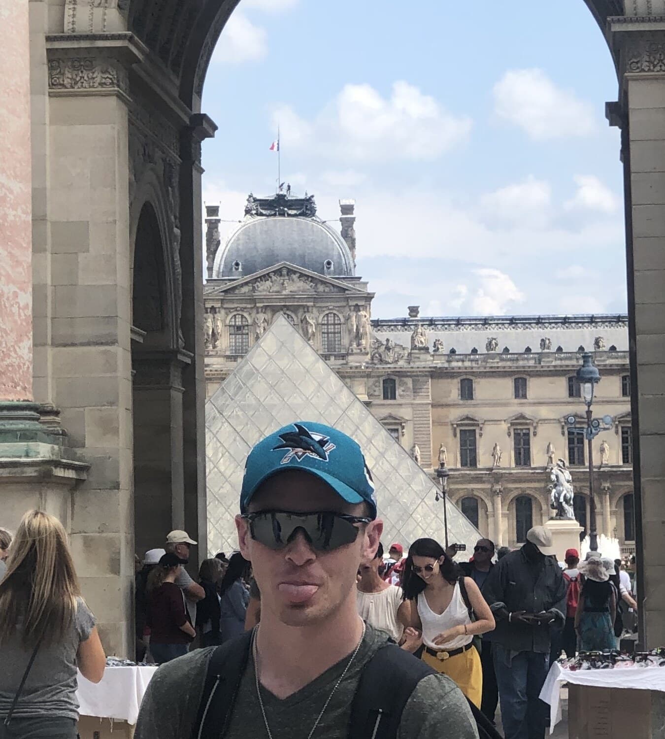 Austin standing under the Louvre arch with the pyramid behind him.