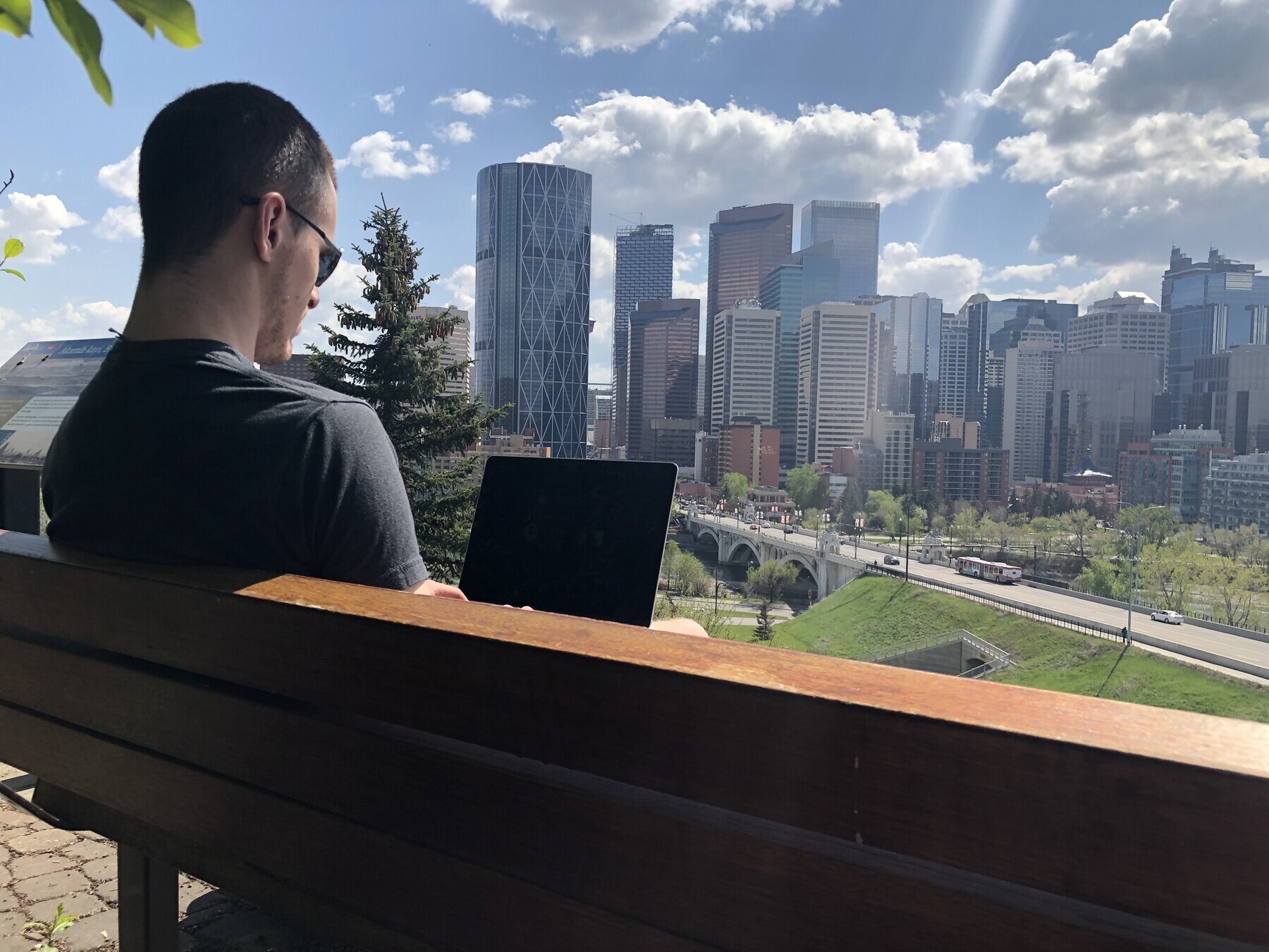 Austin working outside with the Calgary skyline in the background.